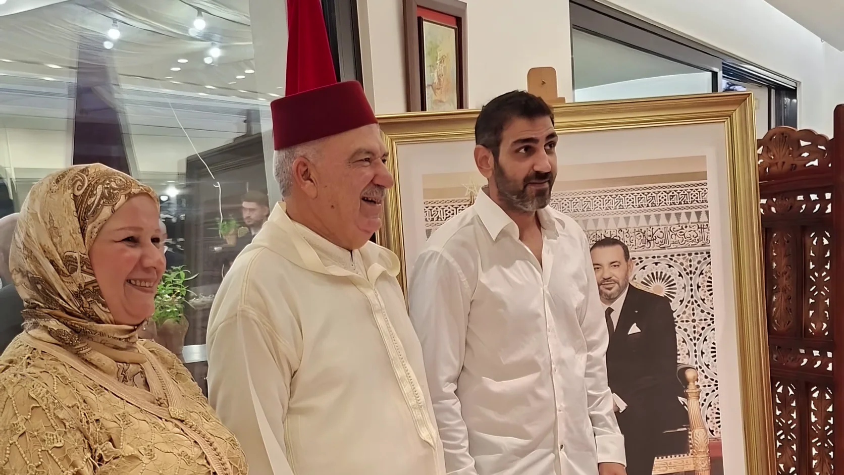 חג הכס בבית נציג מרוקו בישראל: נציג מרוקו ורעייתו ליד תמונת המלך מוחמד השישי