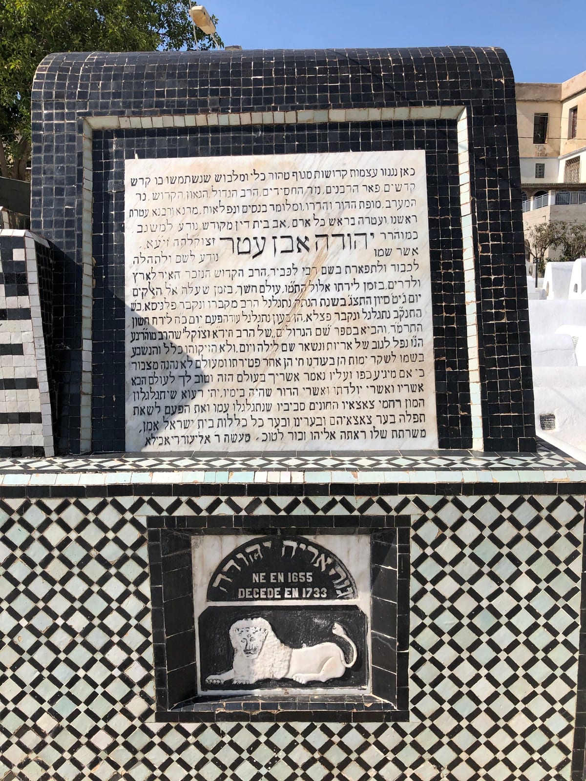 הקבר של רבי יהודה בן עטר בבית העלמין היהודי בפאס. למעלה הלוח עם סיפור חייו, למטה האריה.
